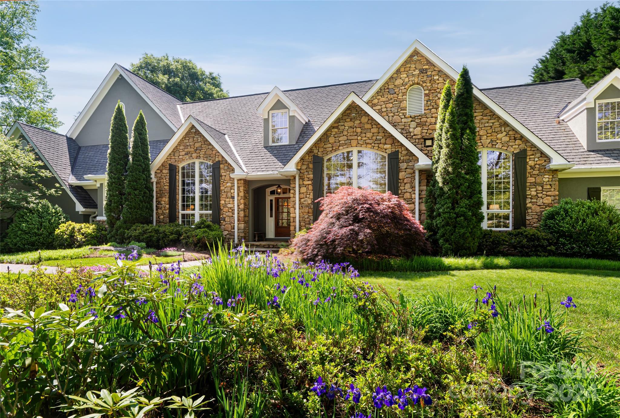 a view of a house with a big yard and potted plants