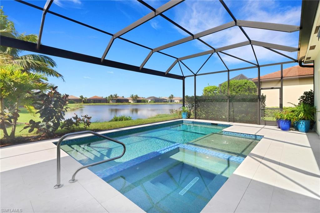 View of swimming pool with a patio, an in ground hot tub, a water view, and a lanai