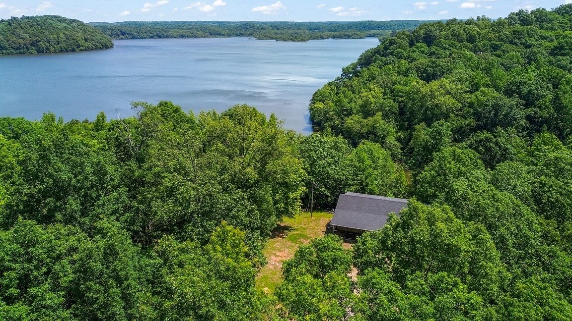 an aerial view of a house with a yard and lake view