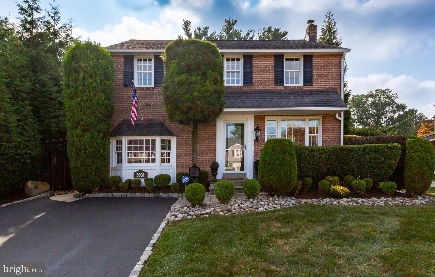 a front view of a house with a garden and plants