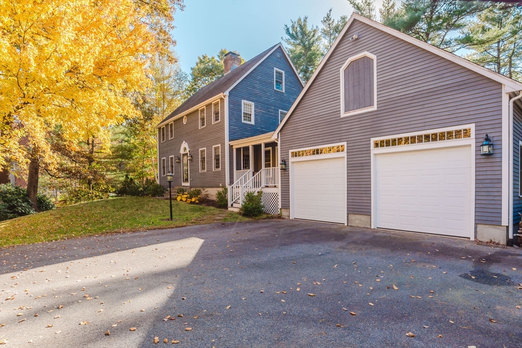 a view of a house with a yard and large tree