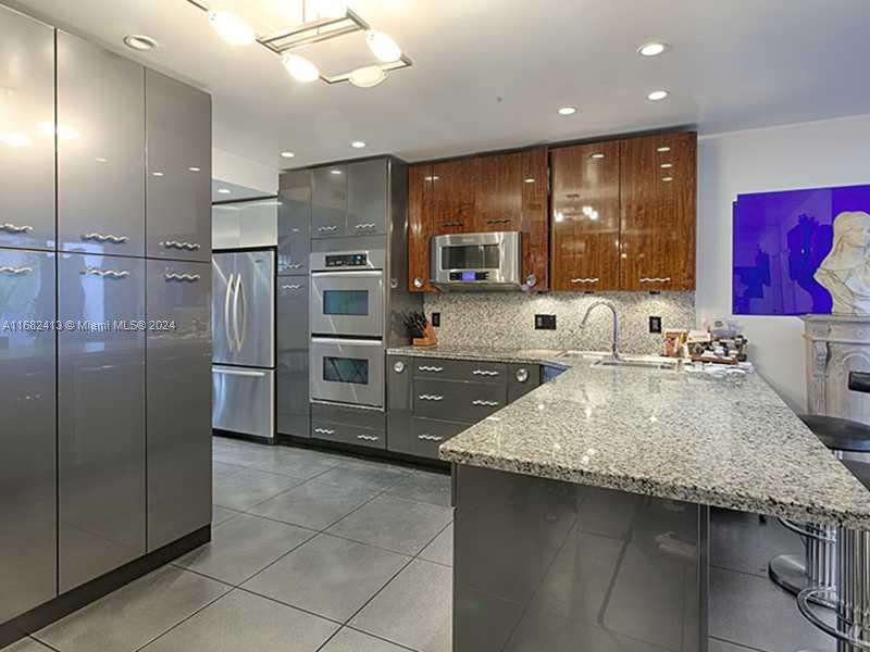 a kitchen with stainless steel appliances granite countertop a sink counter space cabinets and a counter top space