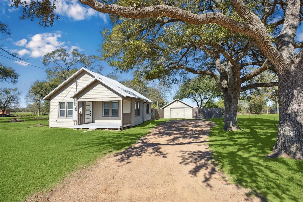 a front view of a house with a yard and trees