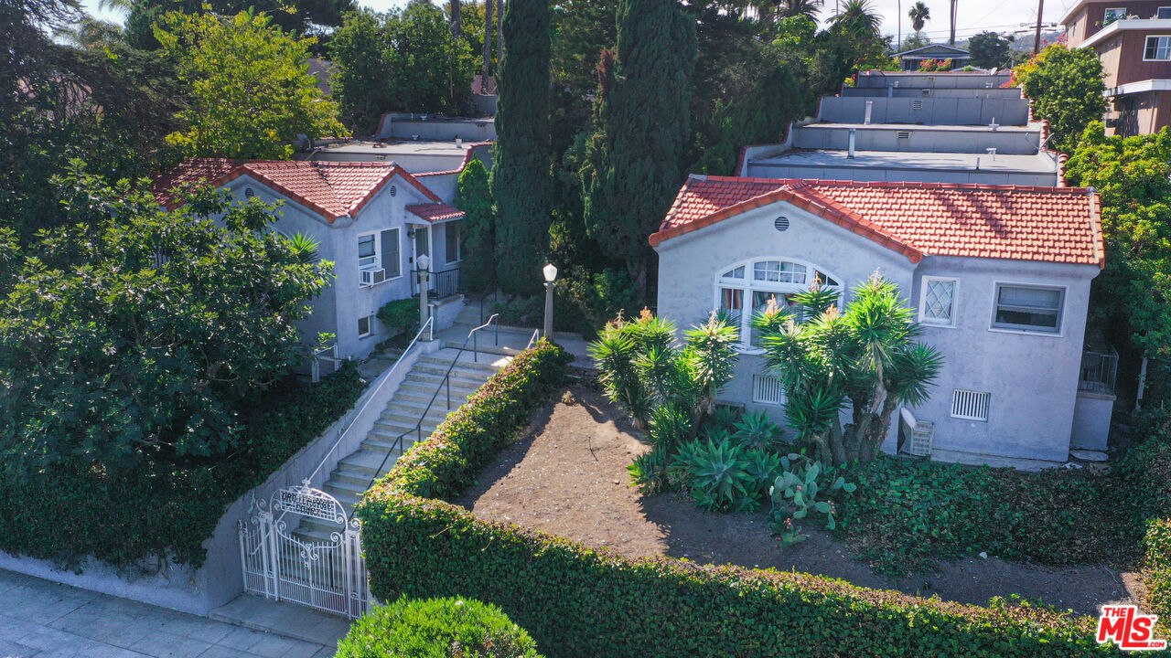 a aerial view of a house with a yard and potted plants