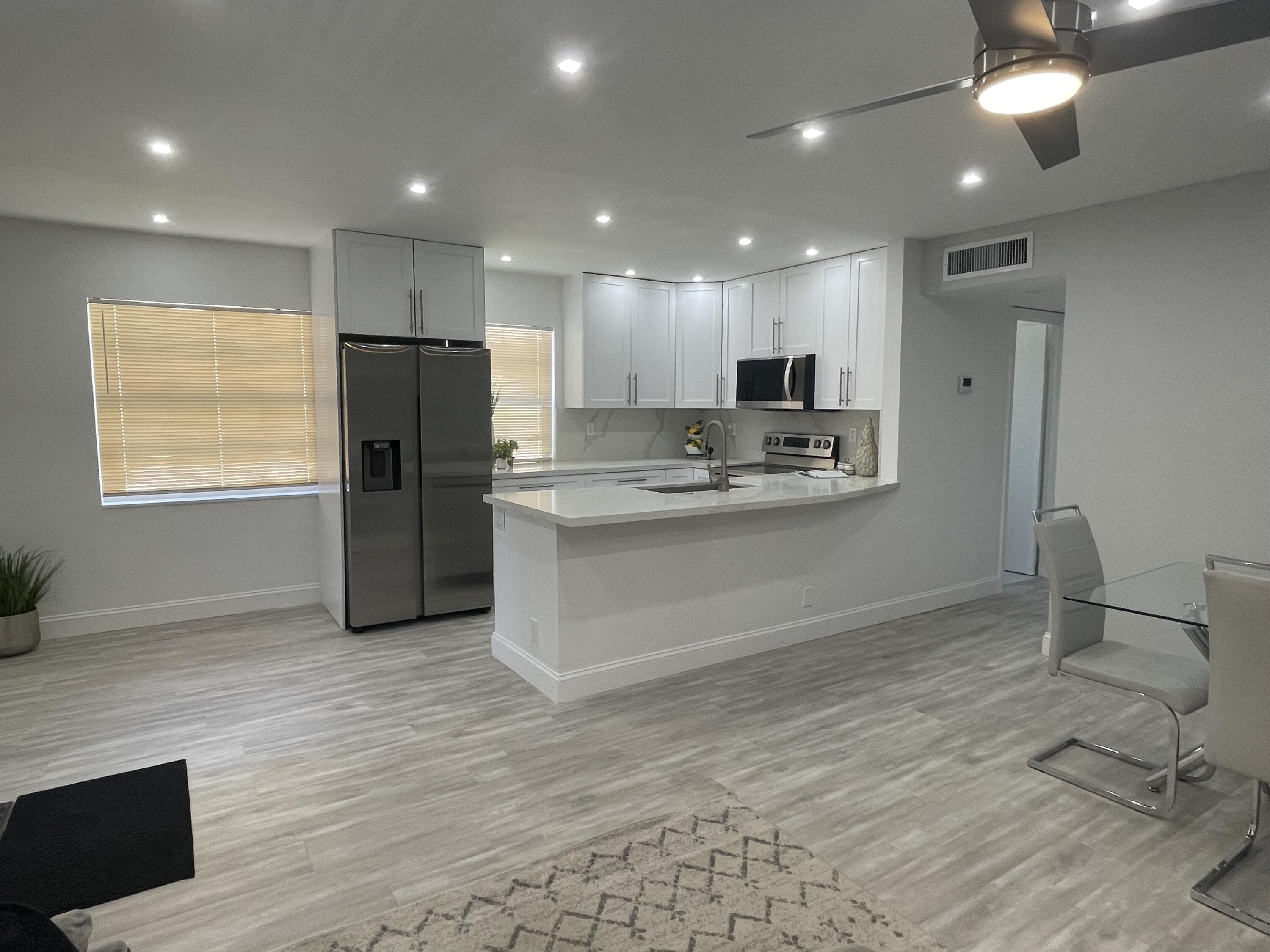 a kitchen with kitchen island stainless steel appliances a refrigerator and a stove top oven