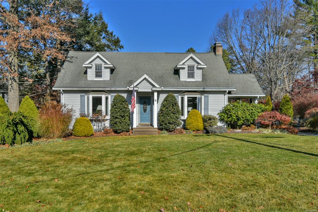 Cape cod home featuring a front yard