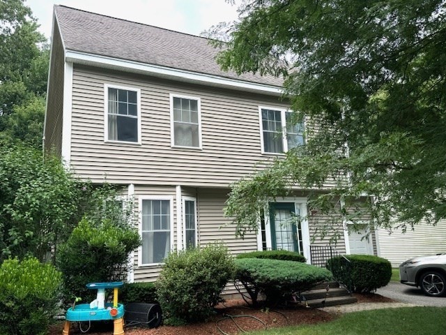 a front view of a house with a yard and potted plants