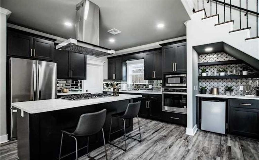 a kitchen with stainless steel appliances kitchen island granite countertop a stove refrigerator and cabinets