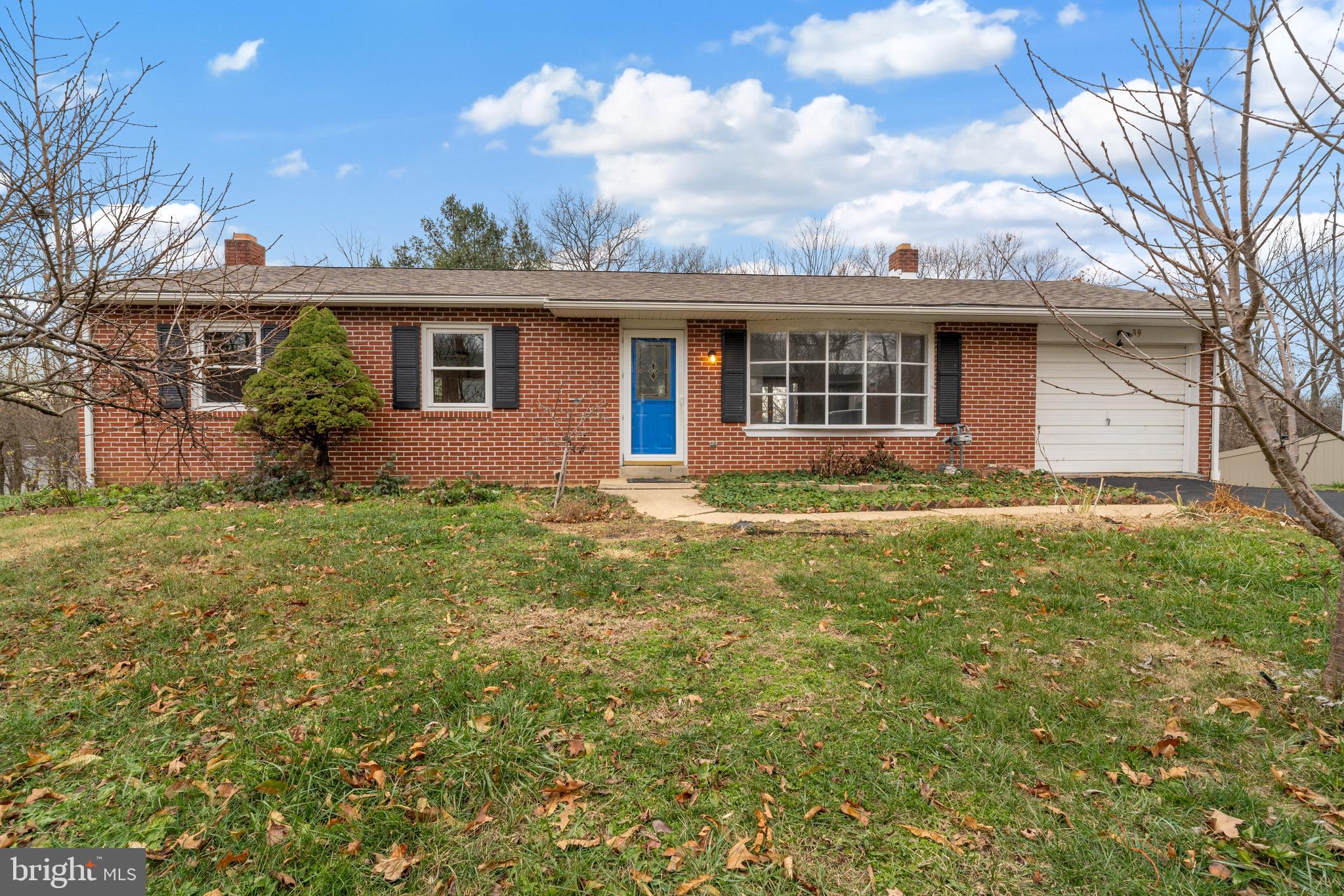 a front view of house with yard and trees around