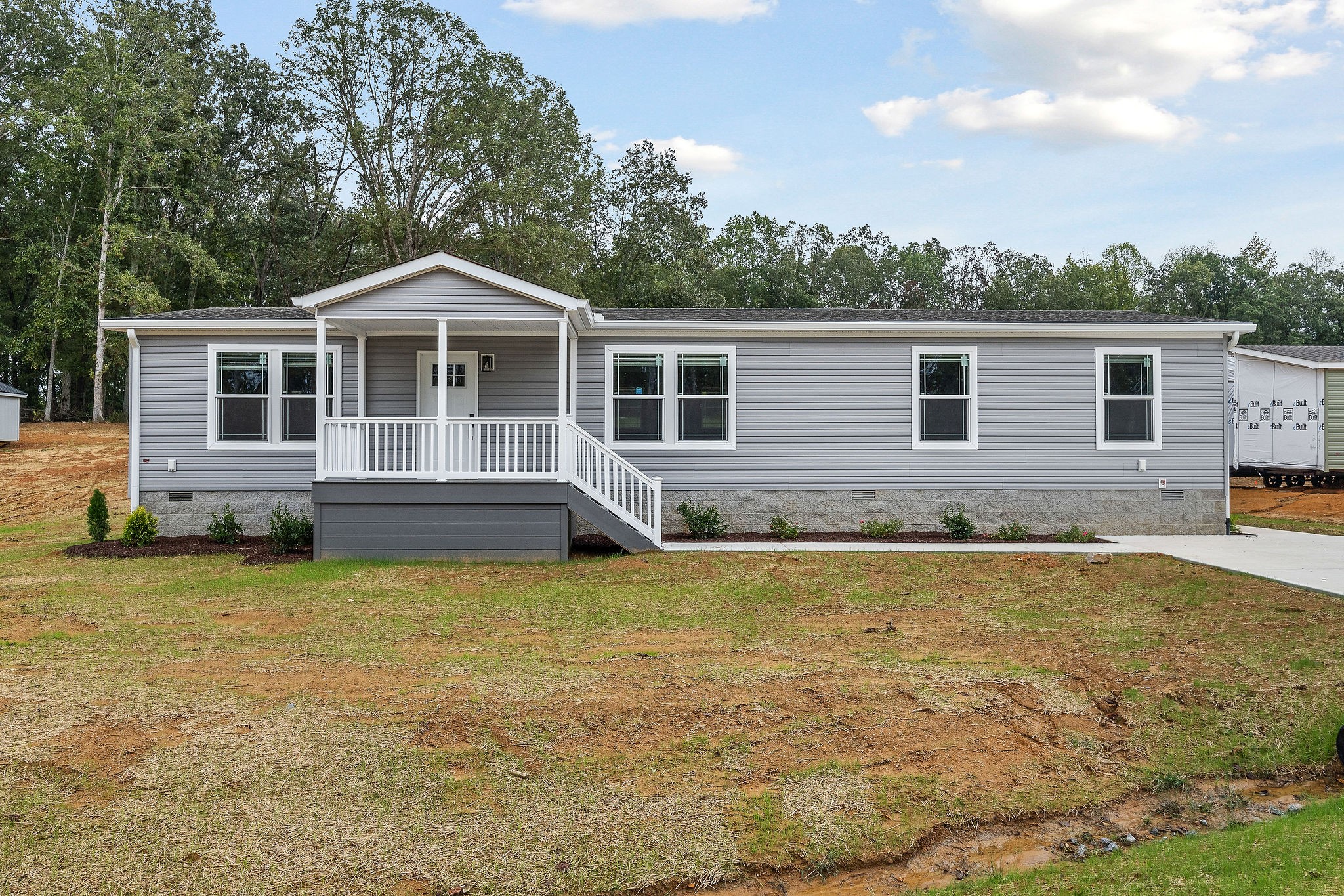 a front view of a house with yard and green space