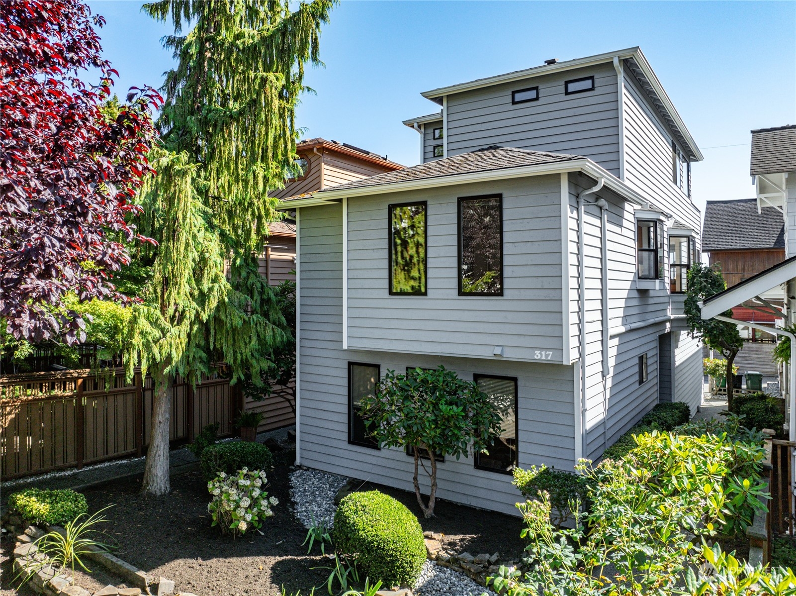 a front view of a house with plants and garden