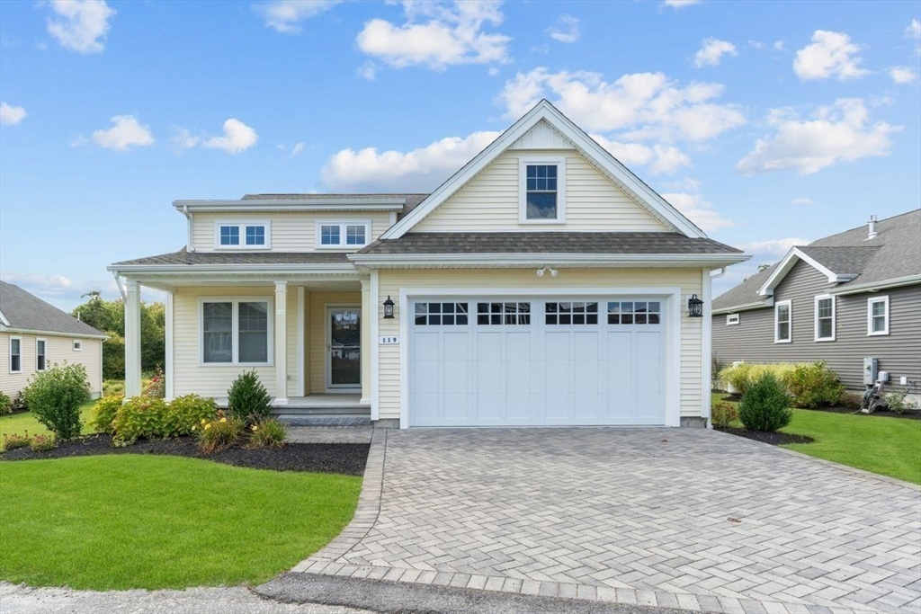 a front view of a house with a garden and garage