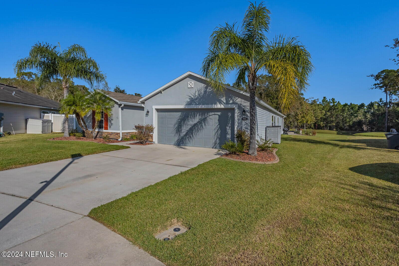 a front view of a house with a yard and a garage