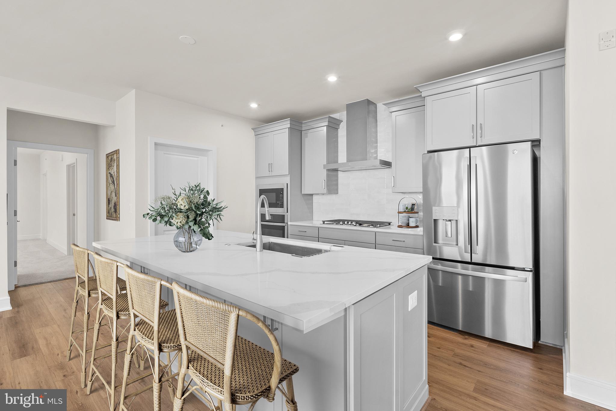 a kitchen with stainless steel appliances a refrigerator and wooden floor