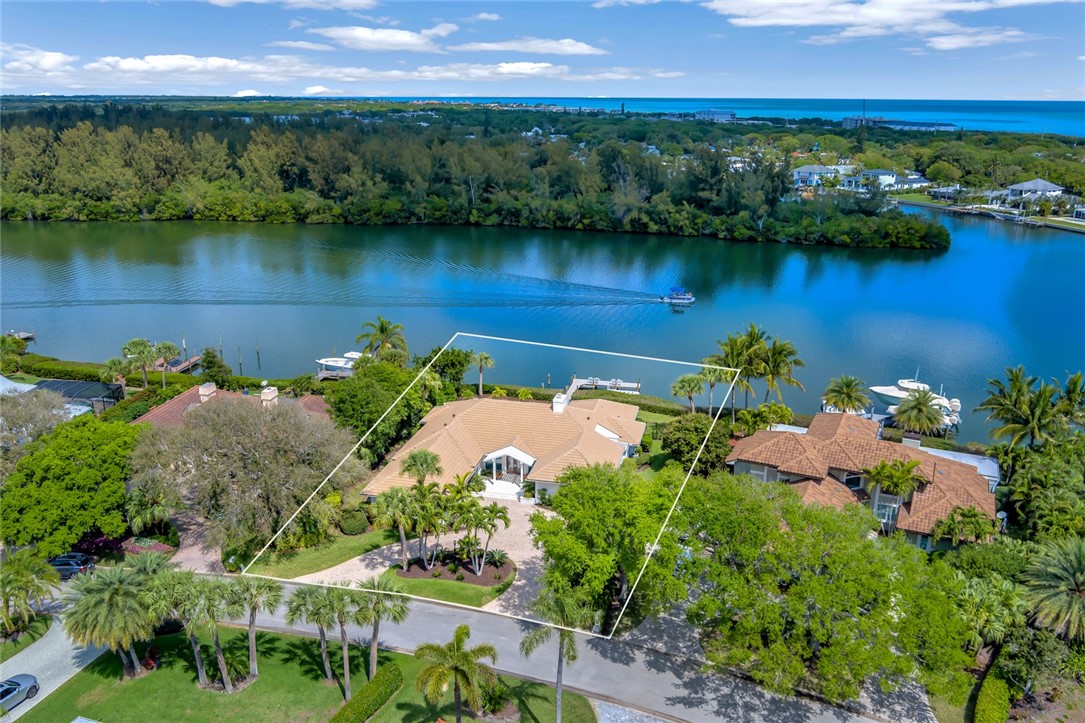 an aerial view of a residential houses with outdoor space and lake view