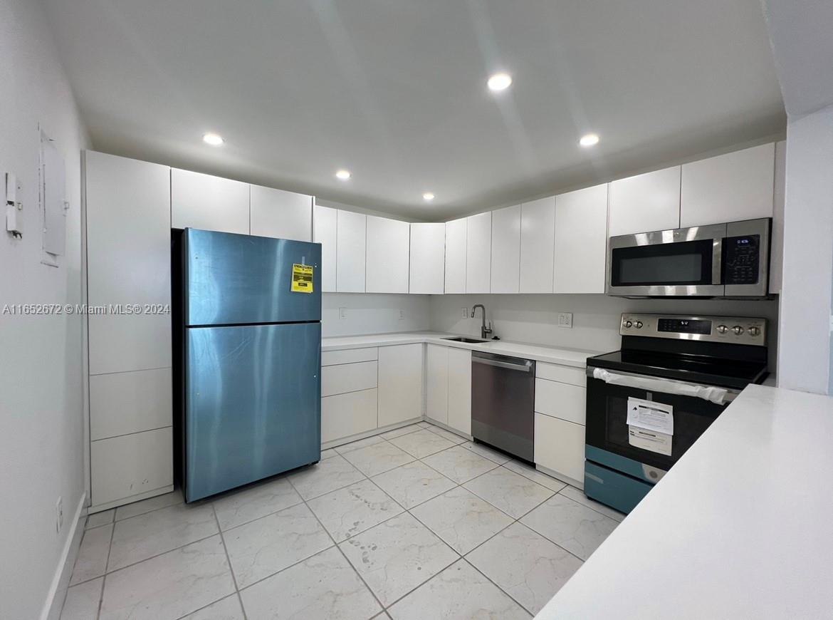 a kitchen with stainless steel appliances granite countertop a refrigerator and a stove top oven