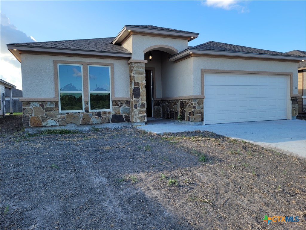 a view of a house with yard and garage