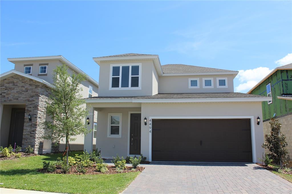 a front view of a house with a garden and garage