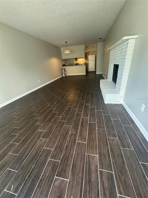 a view of a room with wooden floor and fireplace