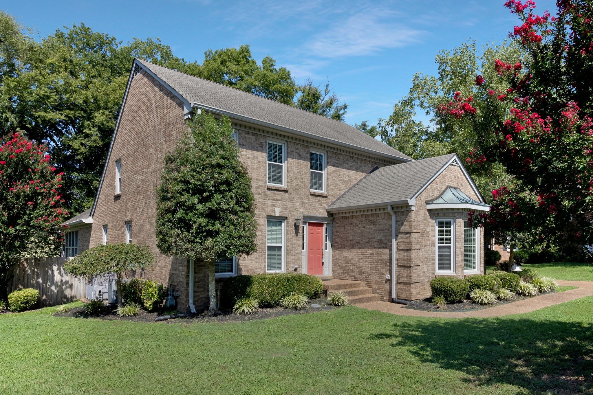 a front view of a house with a garden and plants