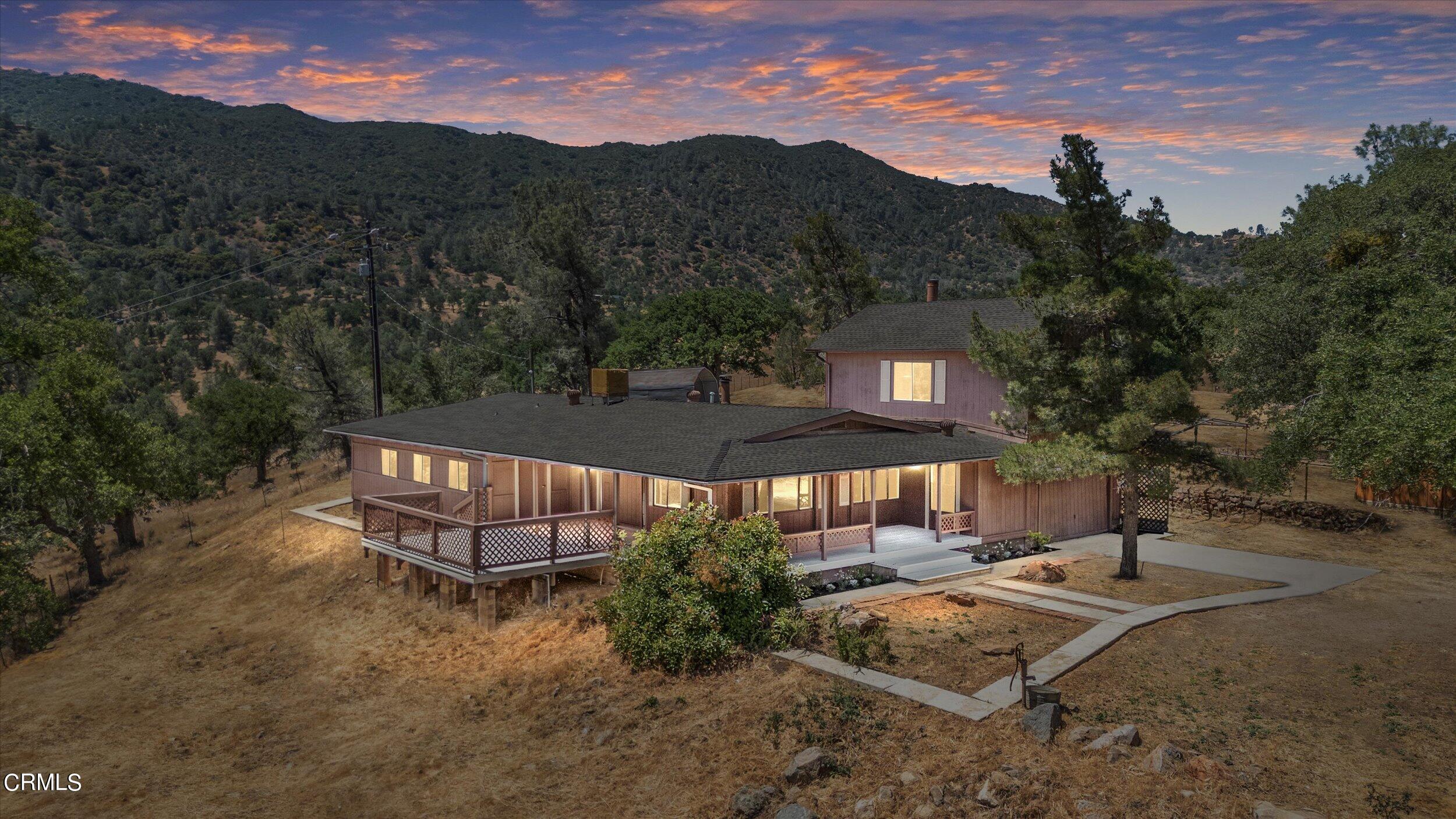 an aerial view of a house with a yard and mountain view