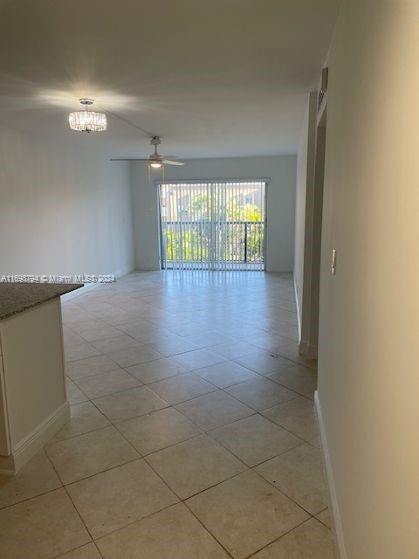 en empty room with windows and chandelier