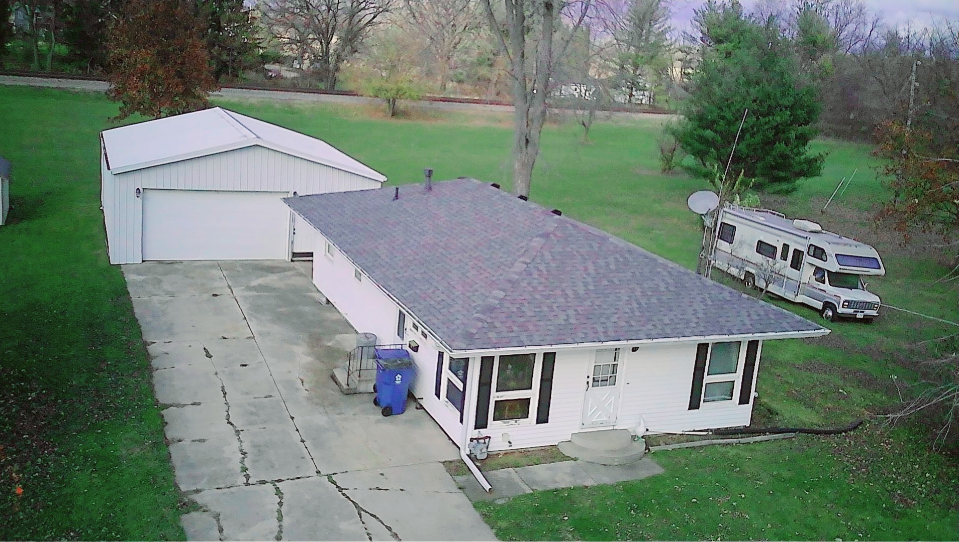 a aerial view of a house next to a big yard and large trees