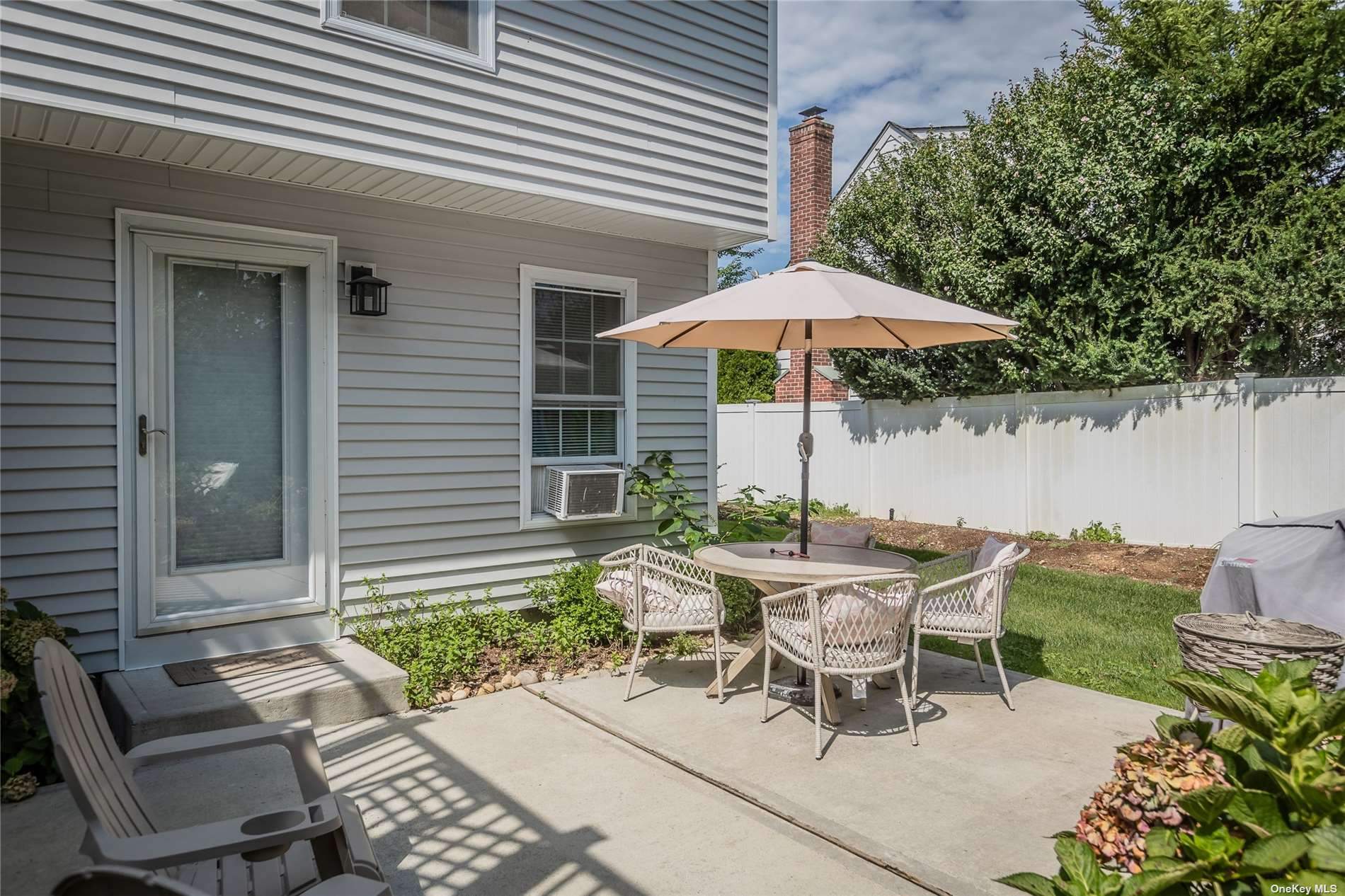 a view of a patio with a table and chairs under an umbrella