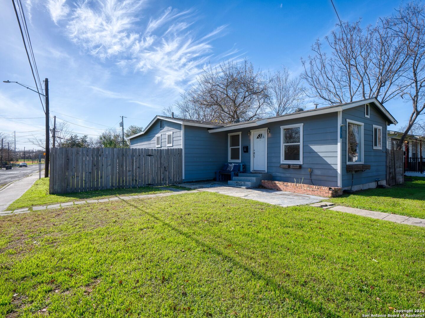 a view of a house with a yard and wooden fence