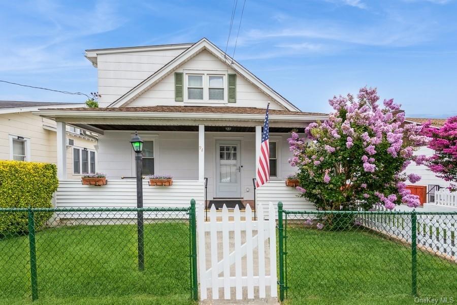 View of front of home with covered porch and a front lawn