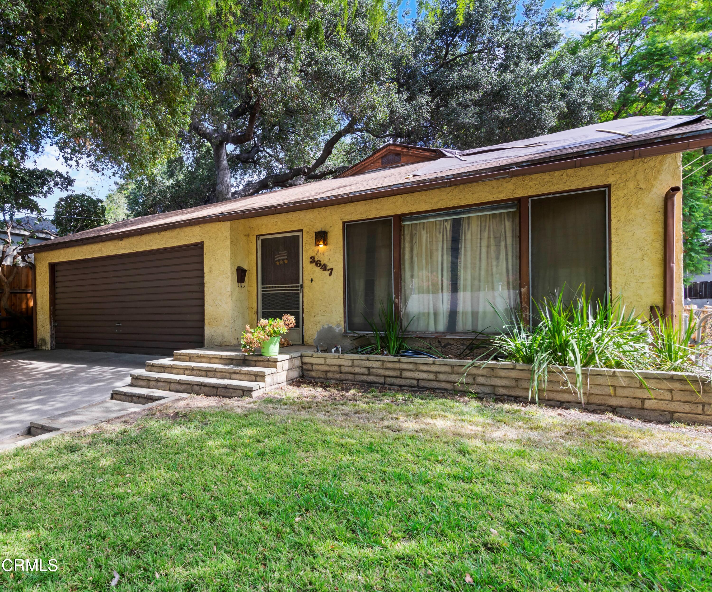 a view of house with backyard and outdoor seating