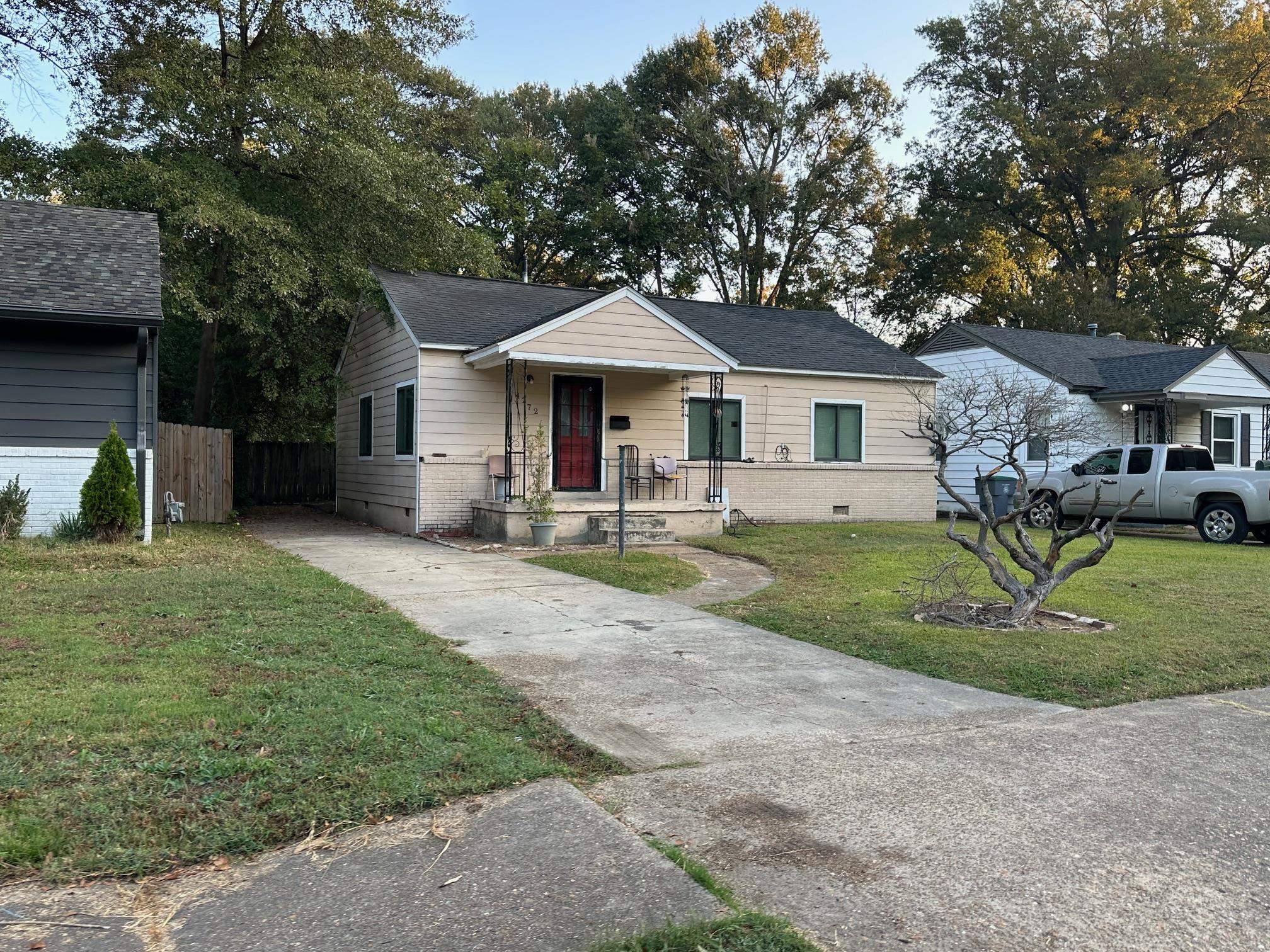 a front view of a house with a yard and trees