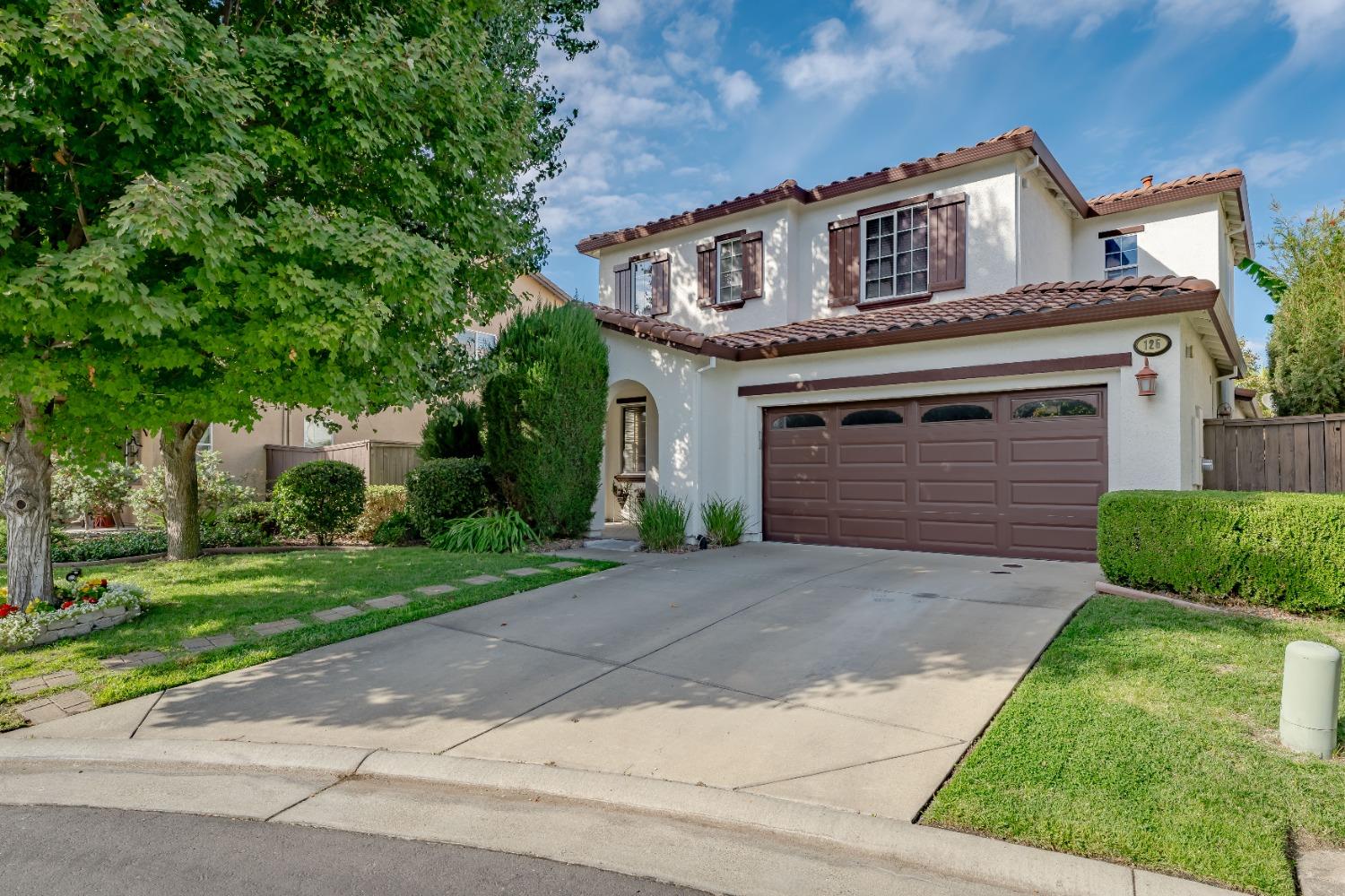 a front view of a house with a yard and a garage