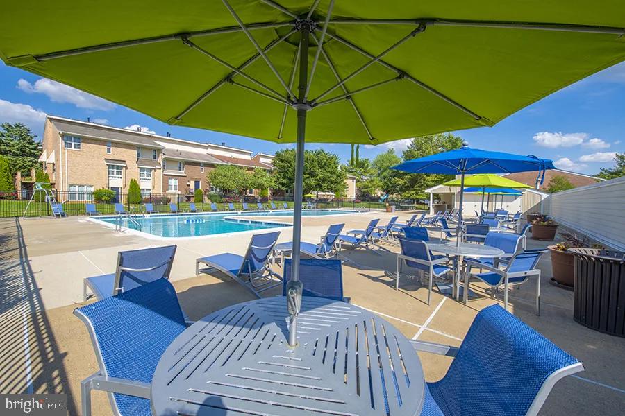 a view of a patio with a dining table and chairs under an umbrella