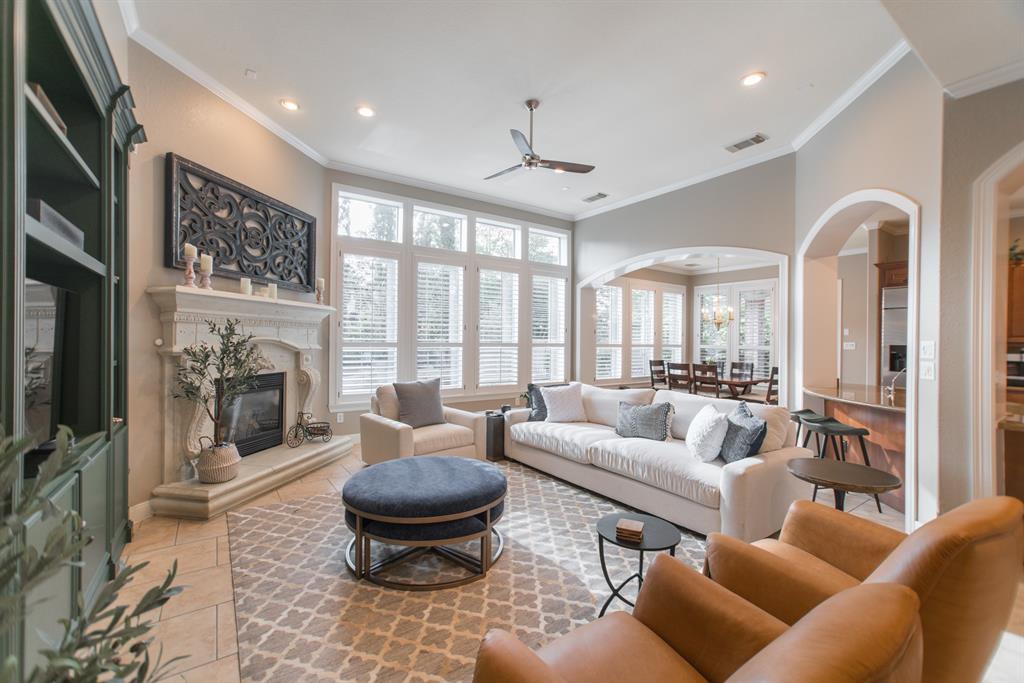 a living room with furniture a fireplace and a floor to ceiling window