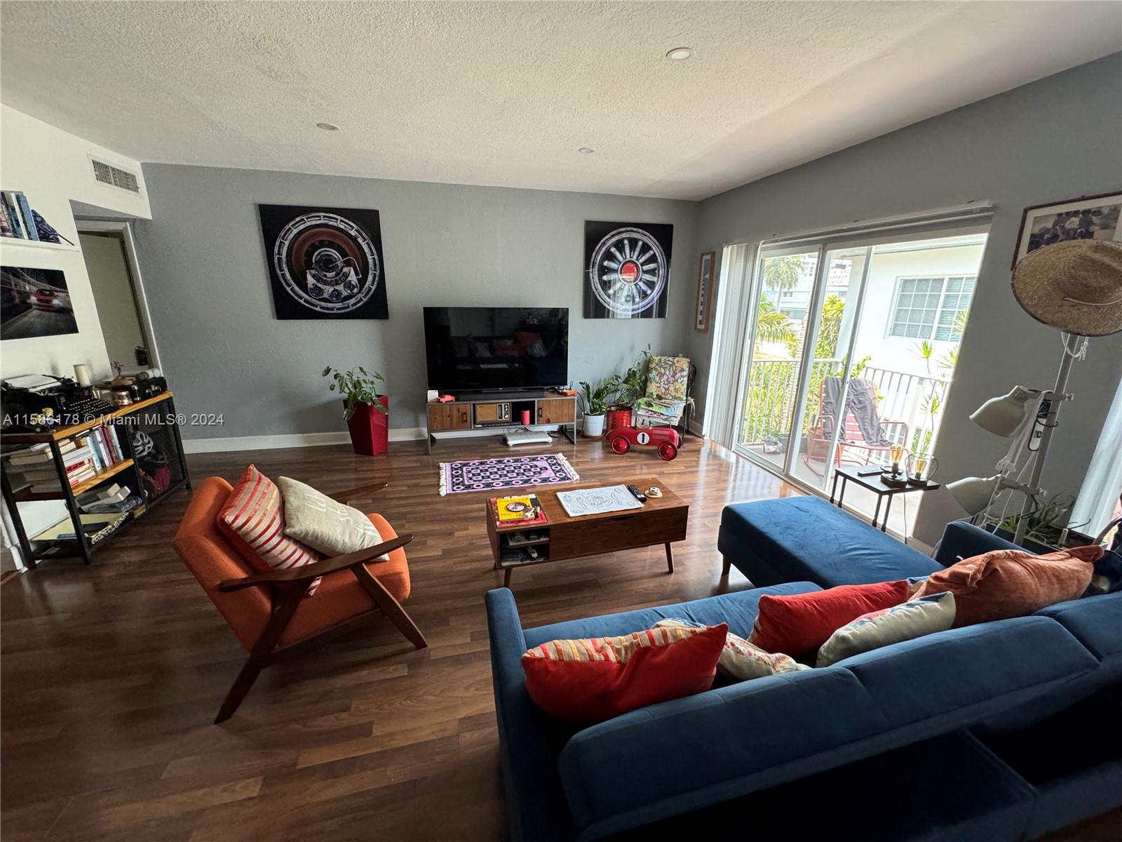 a living room with furniture a flat screen tv and a large window