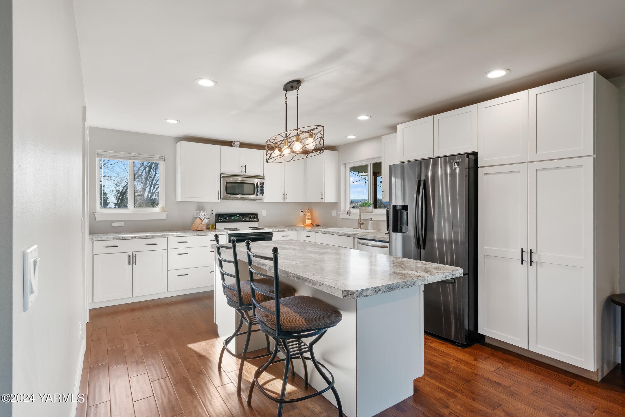 a kitchen with kitchen island a refrigerator stove microwave and cabinets