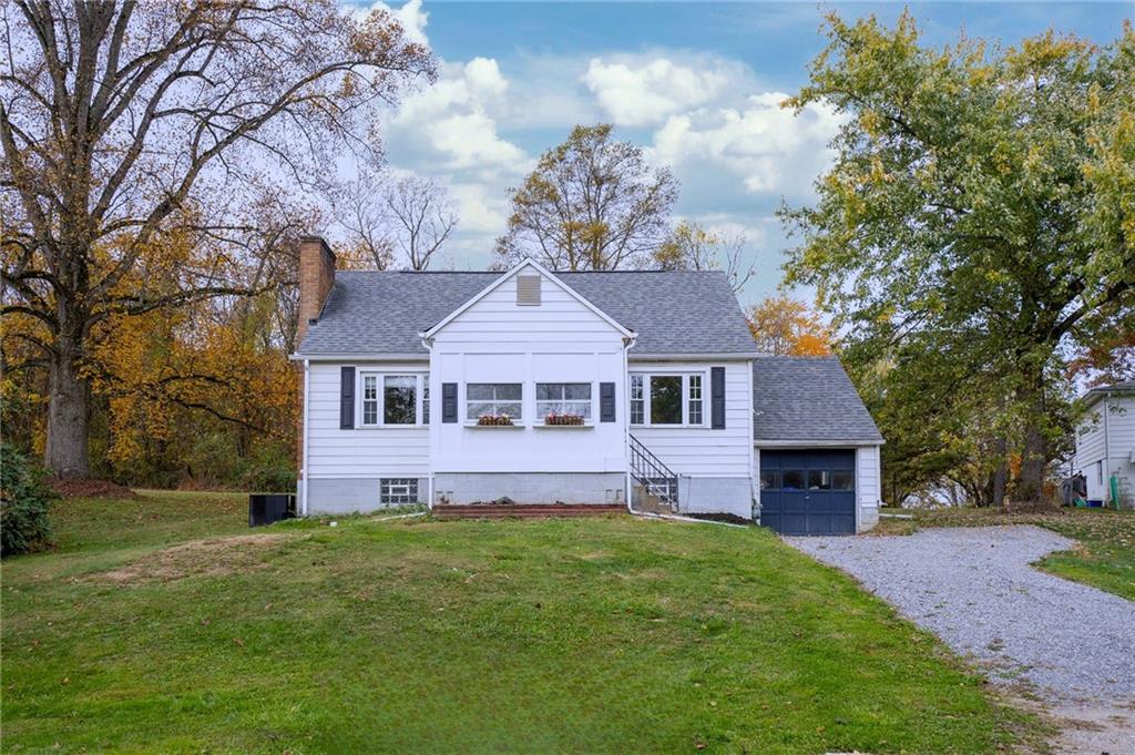 a front view of a house with a garden and trees