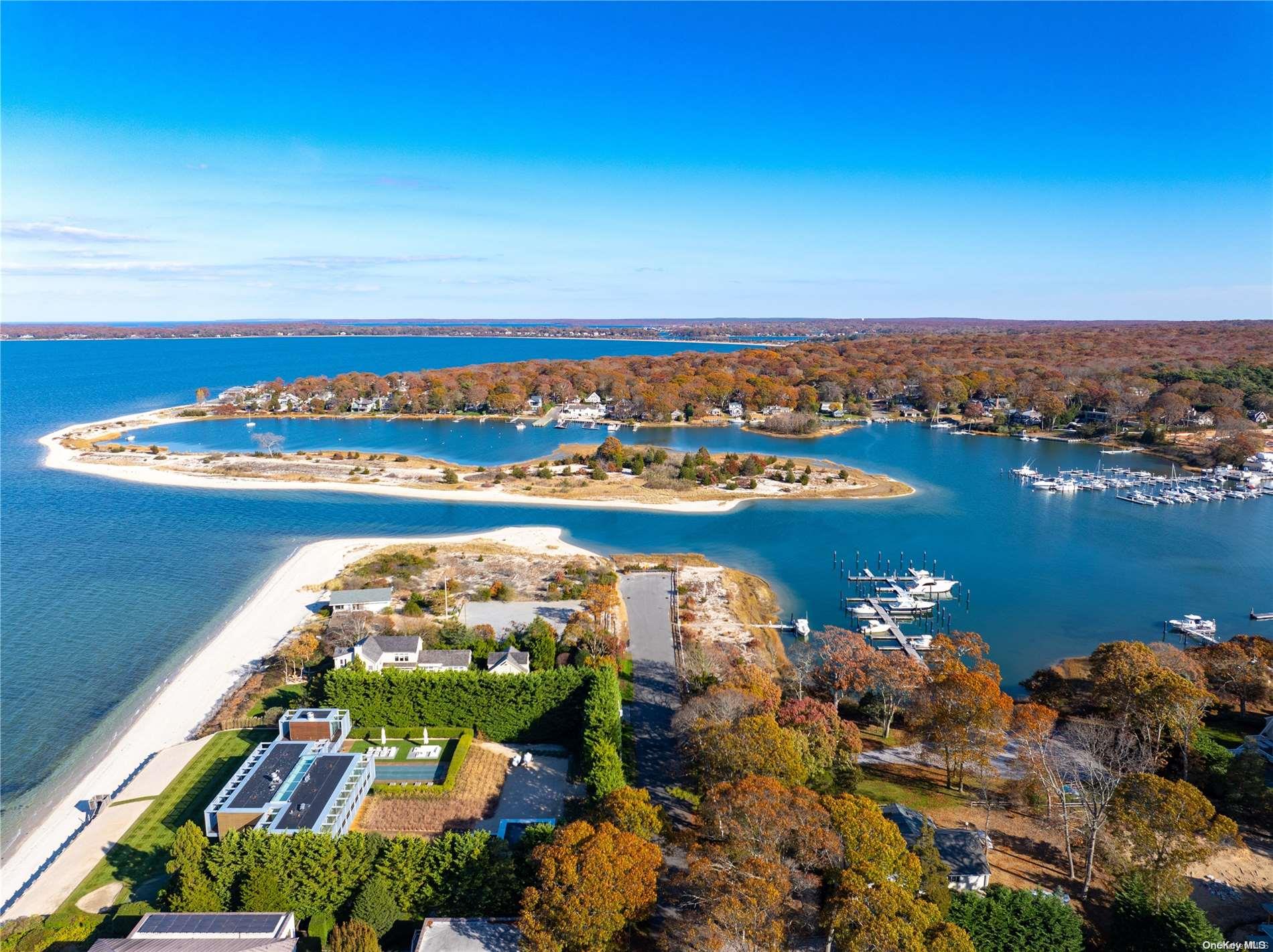 an aerial view of ocean and residential houses with outdoor space