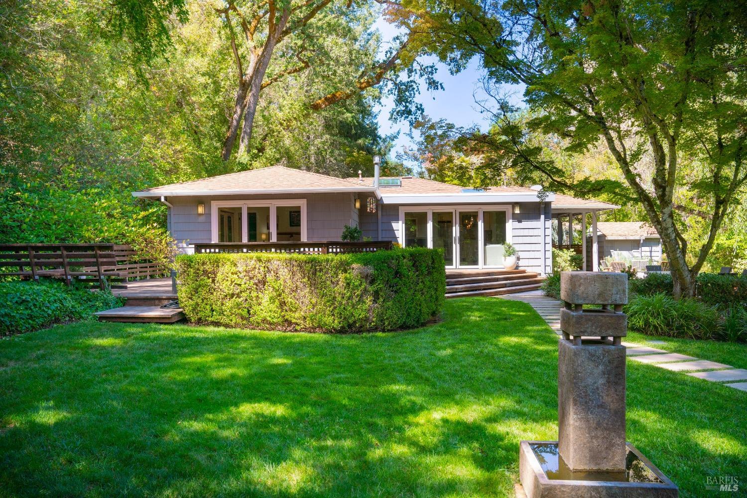 a front view of a house with a yard and trees