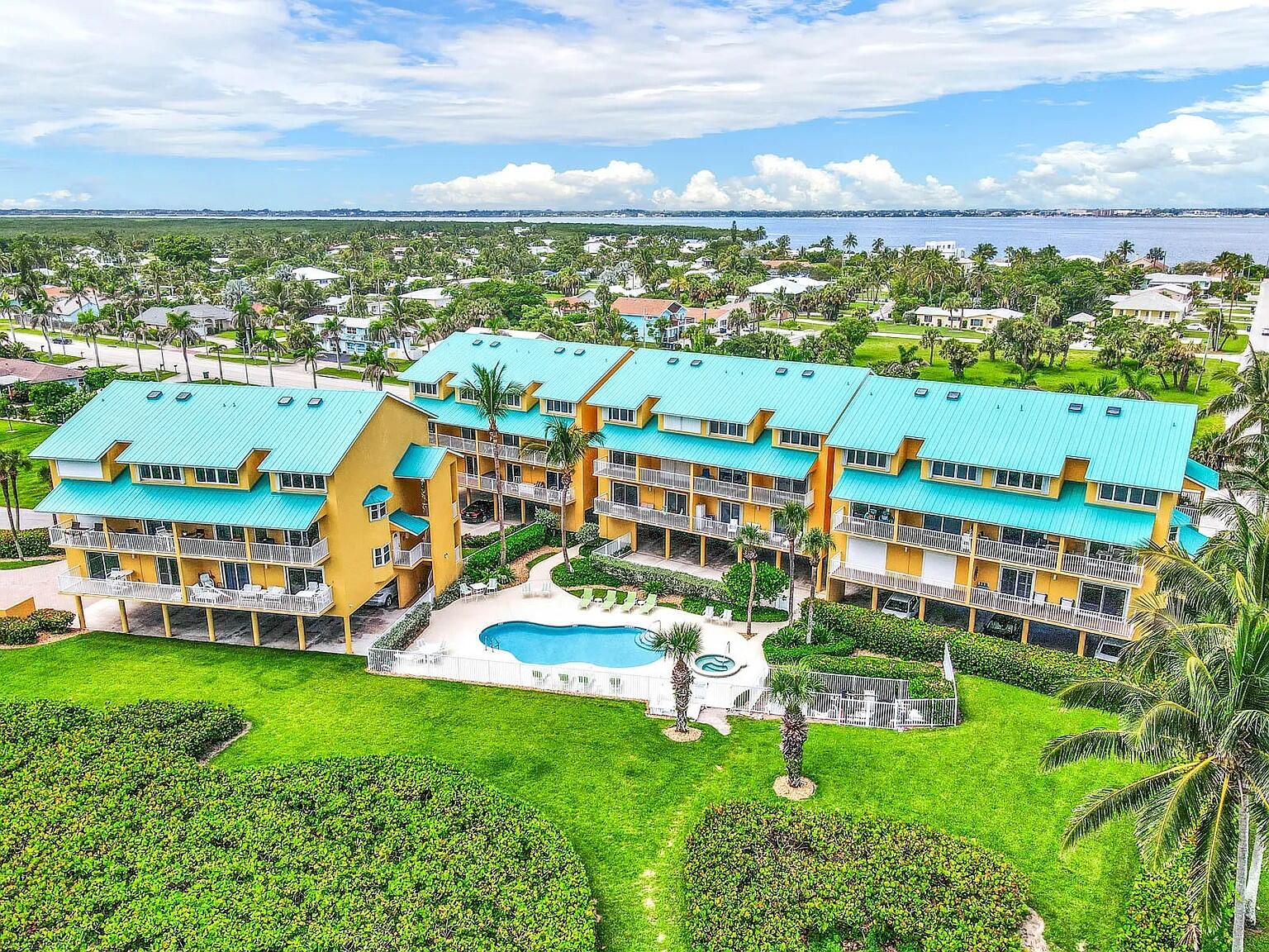 an aerial view of residential houses with outdoor space and ocean view