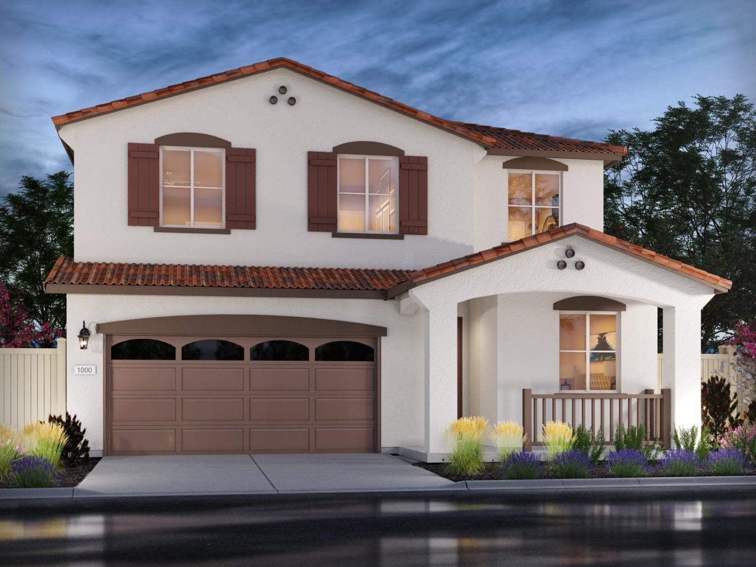 a front view of a house with garage and plants