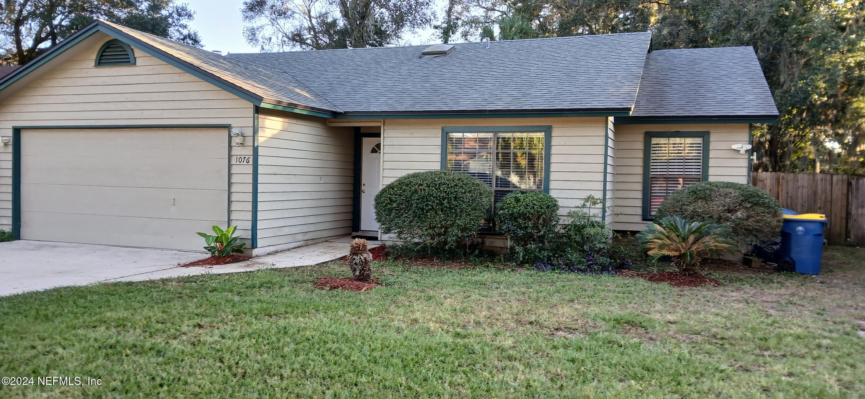 a front view of a house with a yard and potted plants