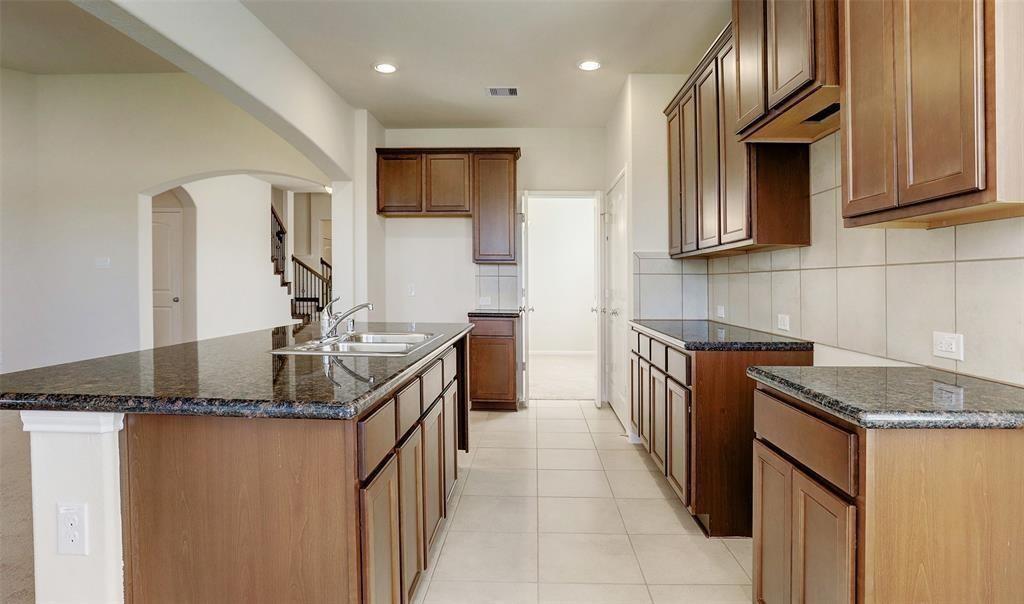 a kitchen with granite countertop a sink stove and cabinets