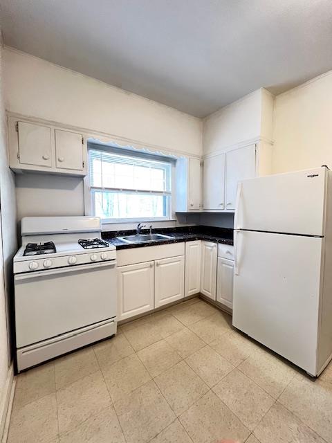 Kitchen featuring white cabinets, white appliances, and sink