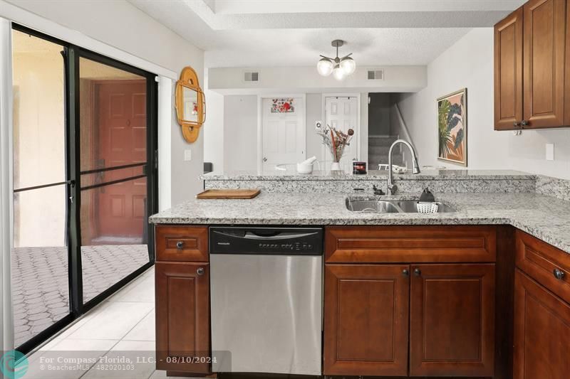 a kitchen with stainless steel appliances granite countertop a refrigerator and a sink