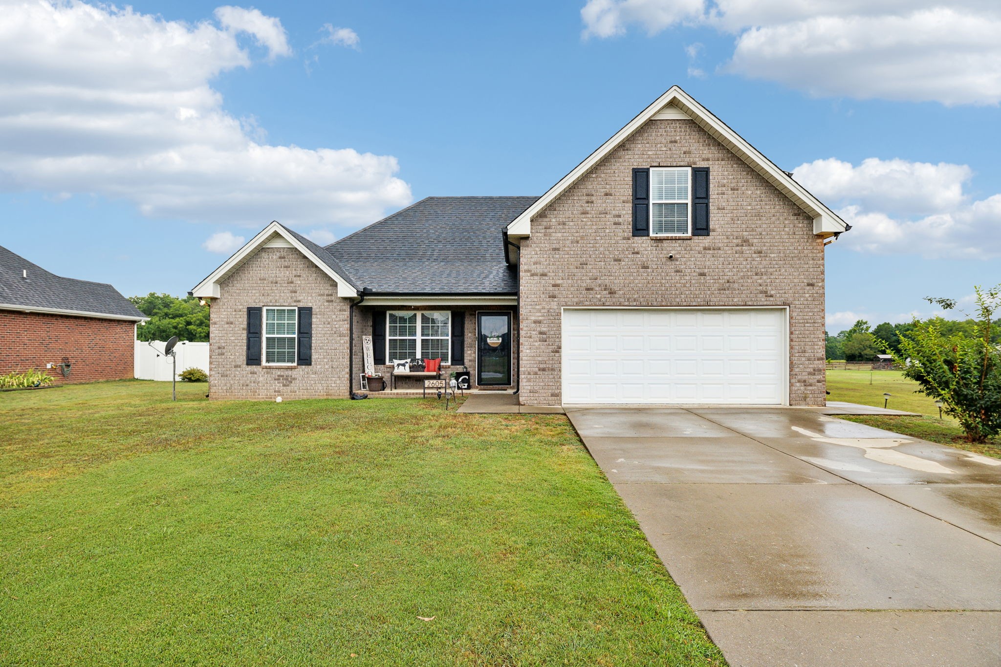 a front view of a house with a garden and yard