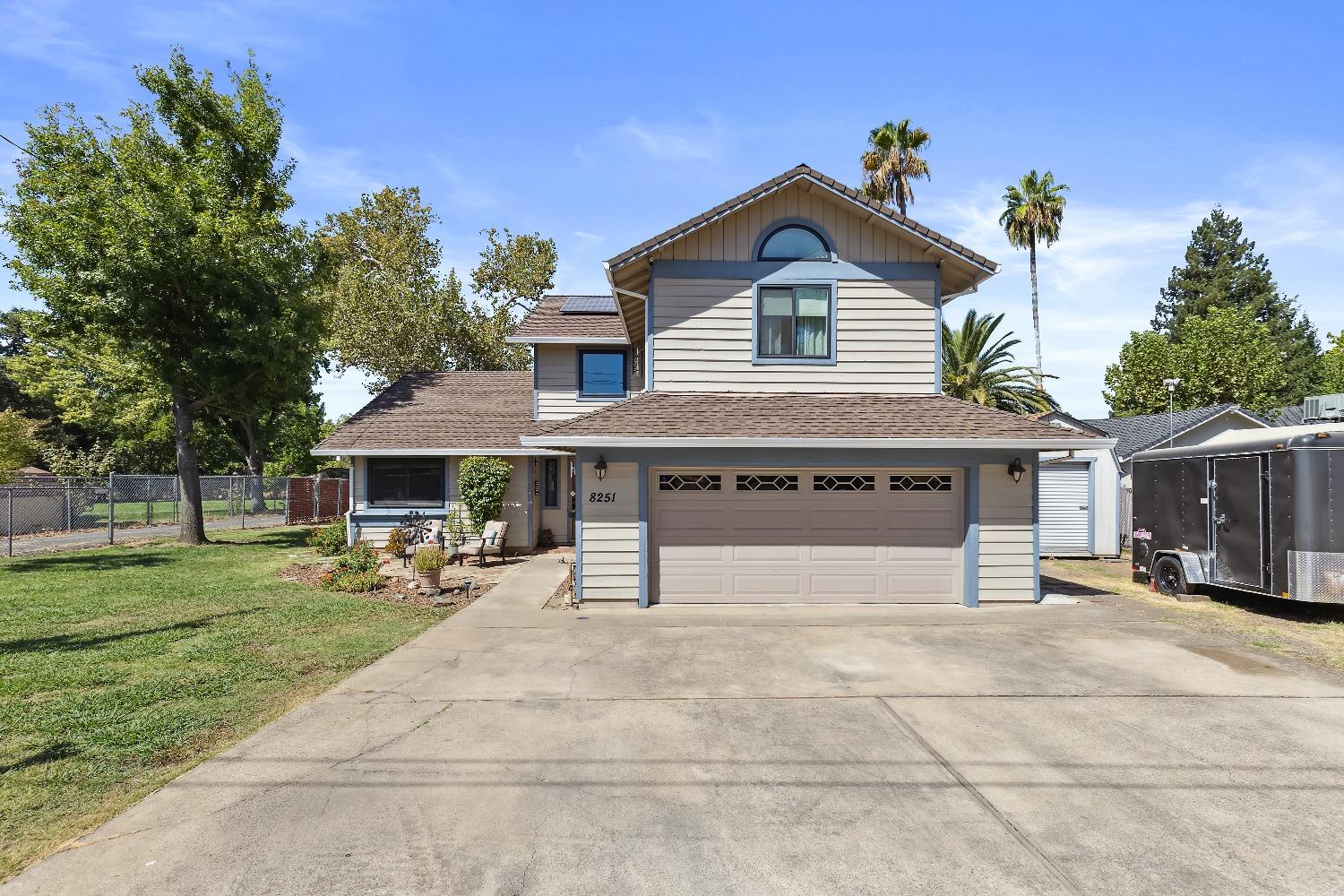 a front view of a house with a yard and trees