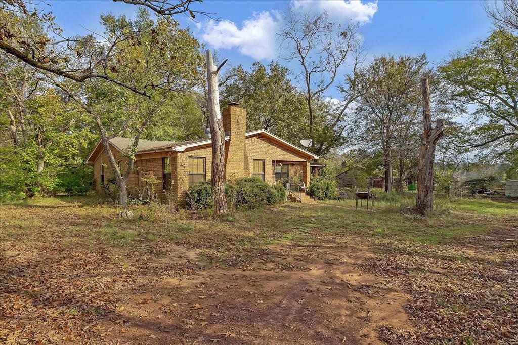 a front view of a house with a yard and trees