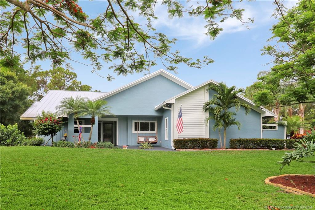 a view of house with a backyard